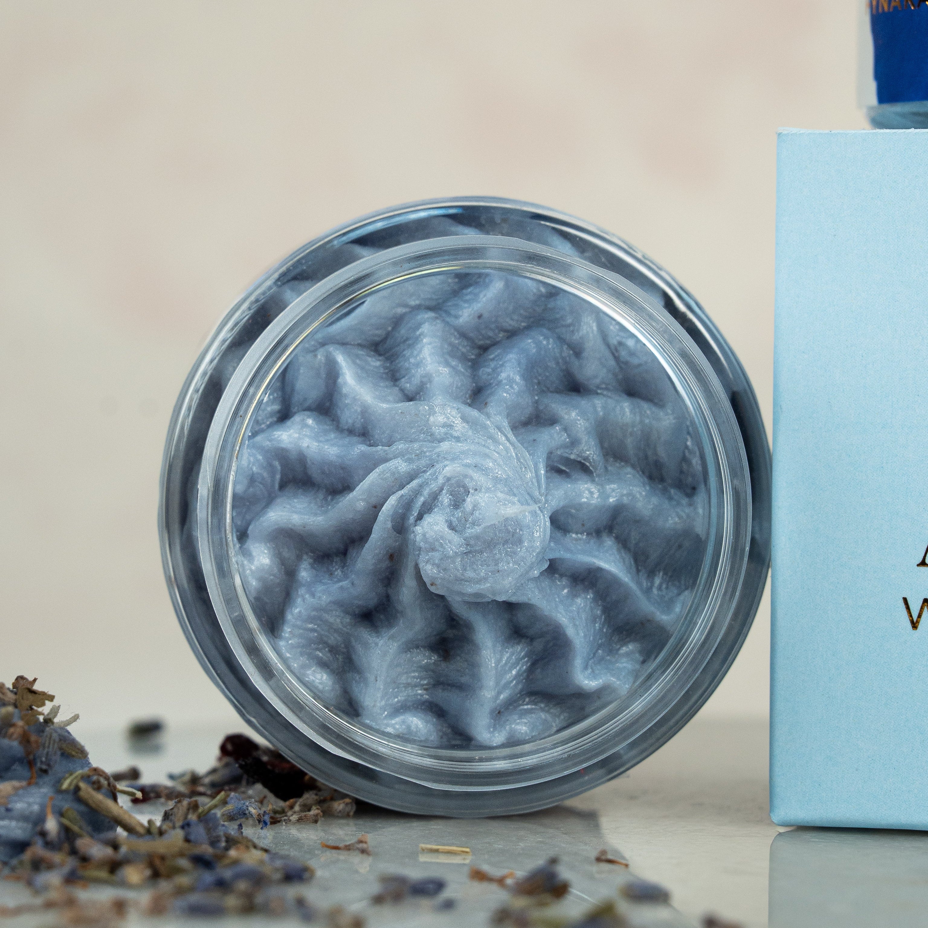 Jar of blue whipped soap on a neutral background