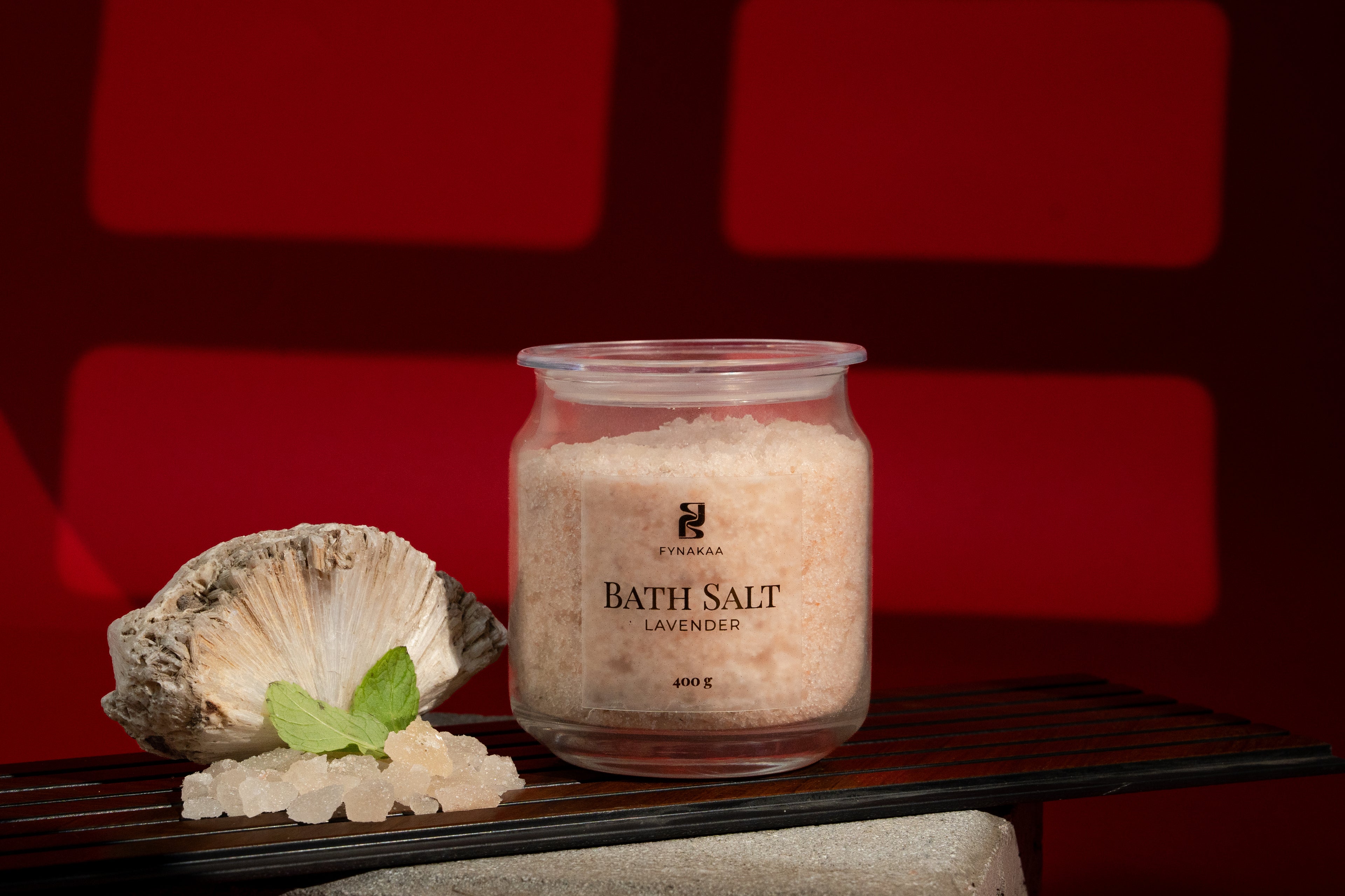 Jar of bath salt with a shell and leaf on a red background