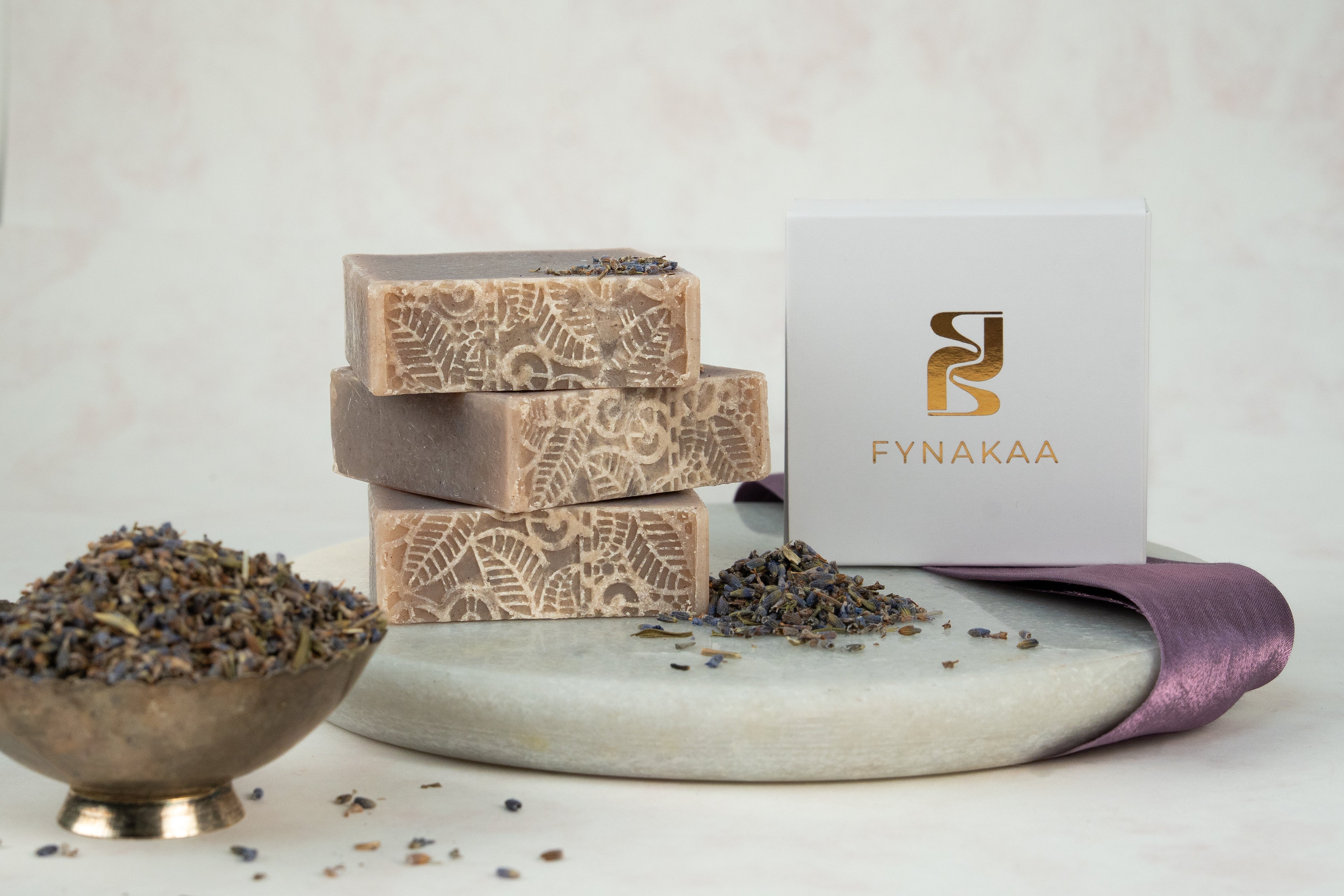 Stack of soap bars with a Fynakaa box on a white background