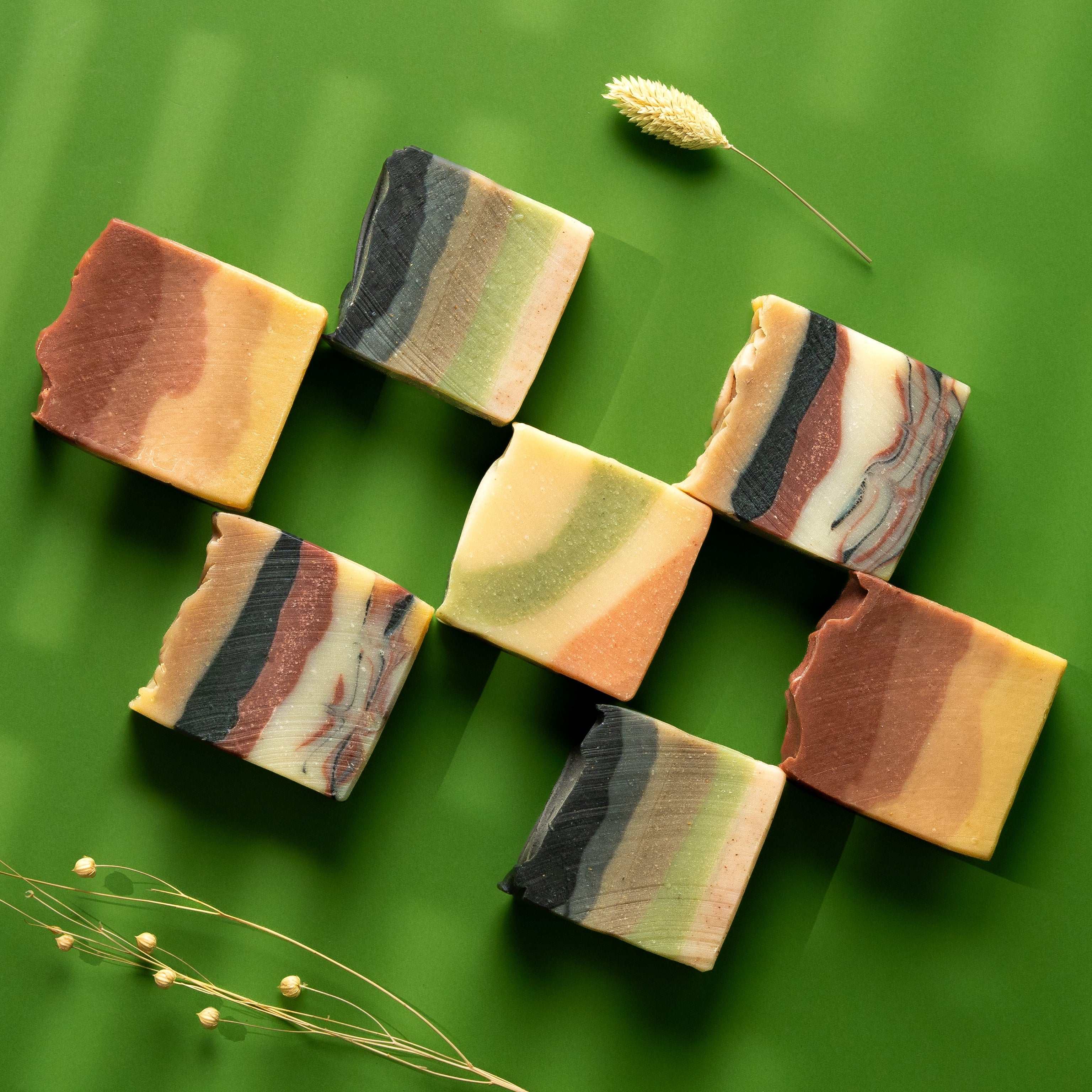Colorful soap bars arranged on a green background